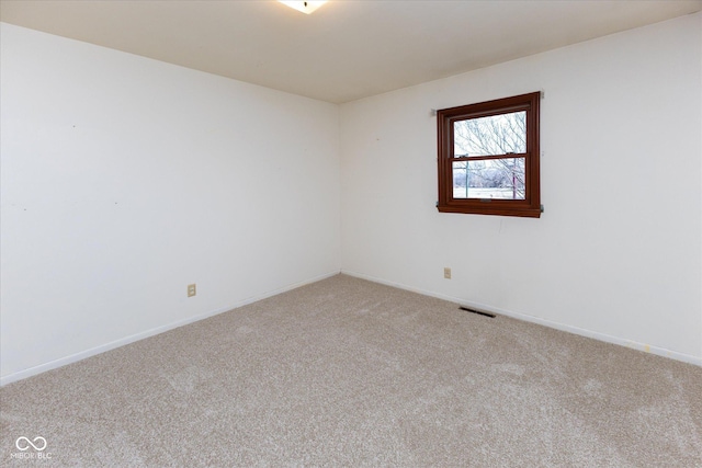 spare room with visible vents, light carpet, and baseboards