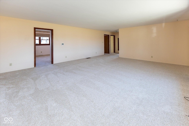 unfurnished room with light colored carpet and visible vents