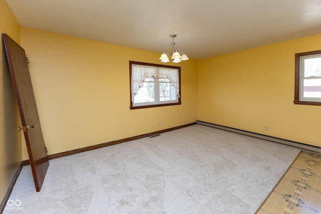 unfurnished room featuring light carpet, a notable chandelier, a baseboard heating unit, and baseboards