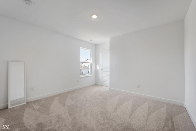 carpeted spare room featuring baseboards