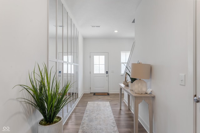 doorway with recessed lighting, wood finished floors, visible vents, and baseboards