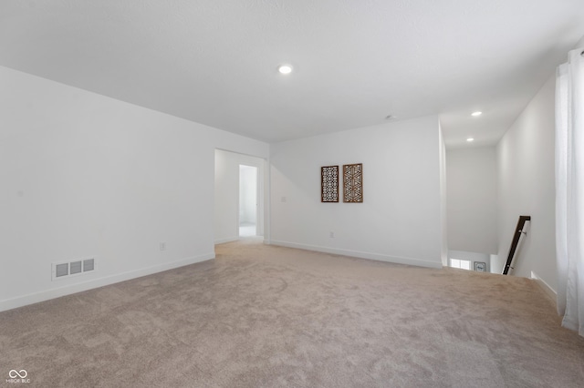 spare room featuring recessed lighting, visible vents, light carpet, and baseboards