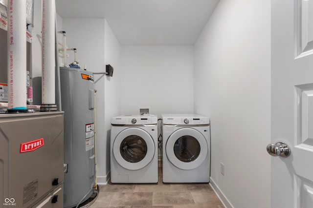 laundry area featuring laundry area, separate washer and dryer, water heater, and baseboards