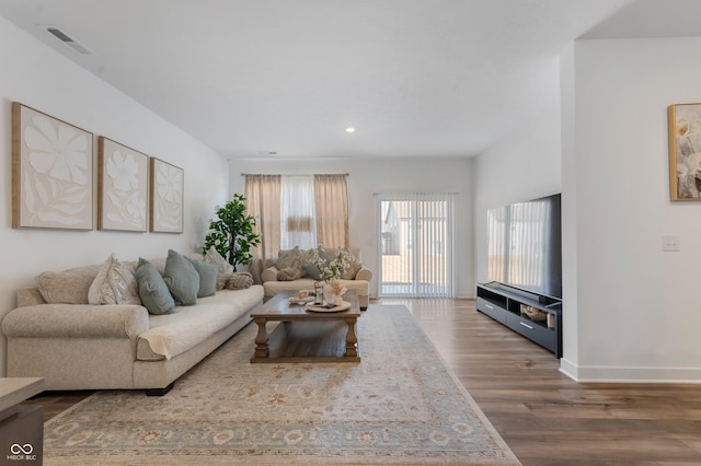 living area with visible vents, recessed lighting, baseboards, and wood finished floors