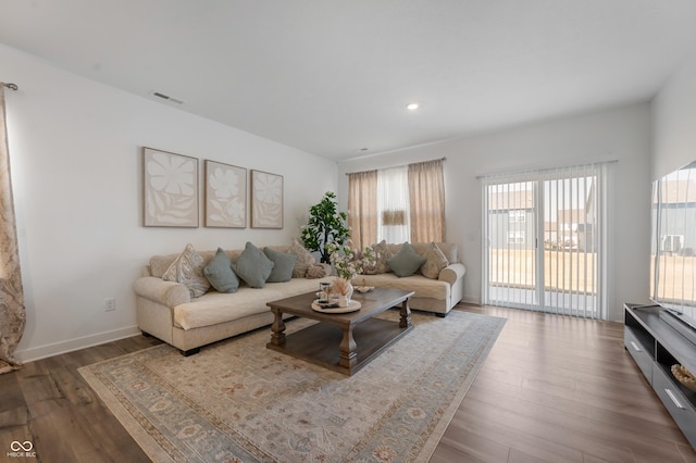 living area with recessed lighting, visible vents, baseboards, and wood finished floors