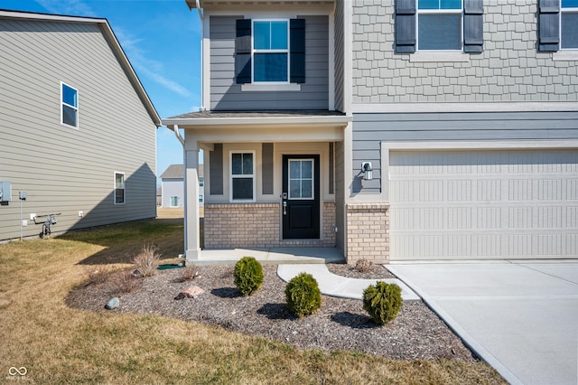 entrance to property featuring brick siding, an attached garage, covered porch, and driveway