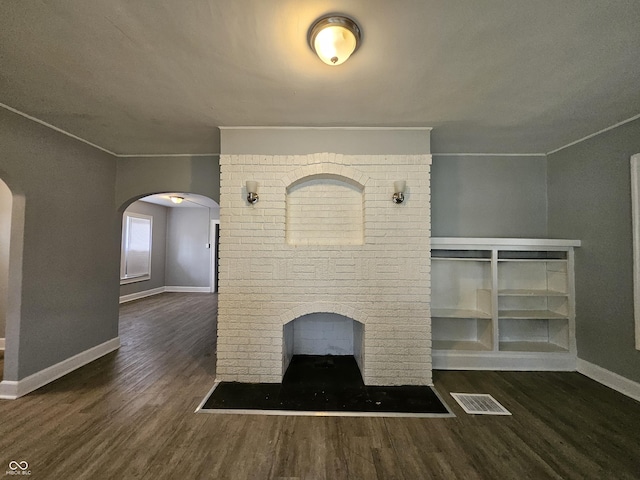 interior details featuring arched walkways, visible vents, ornamental molding, and wood finished floors