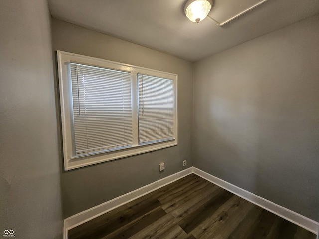 empty room featuring dark wood finished floors and baseboards