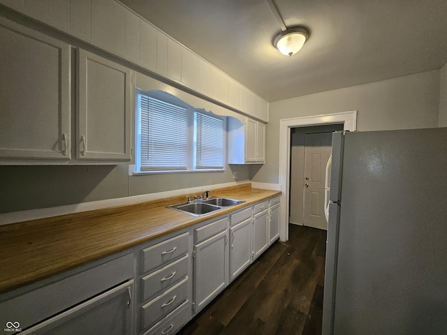 kitchen with gray cabinetry, freestanding refrigerator, dark wood-type flooring, and a sink