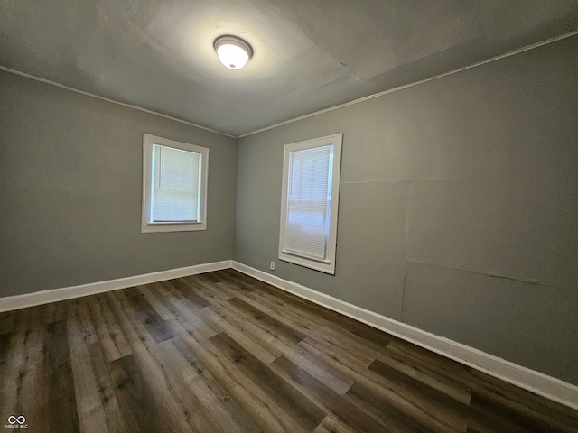 empty room featuring baseboards and dark wood-style flooring