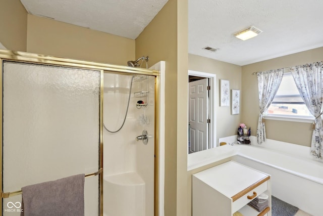 full bathroom featuring visible vents, a stall shower, and a textured ceiling