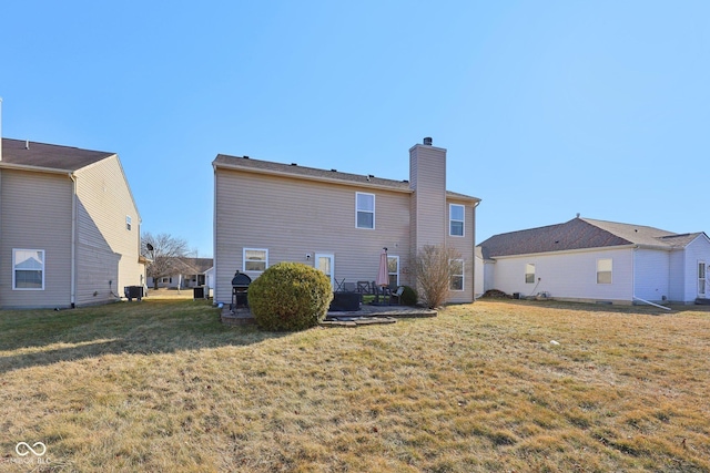 back of house with a patio area, a lawn, a chimney, and central AC