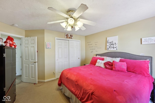 carpeted bedroom with ceiling fan, baseboards, a closet, and a textured ceiling