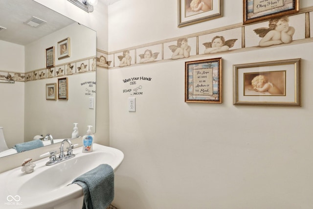 bathroom featuring visible vents and a sink