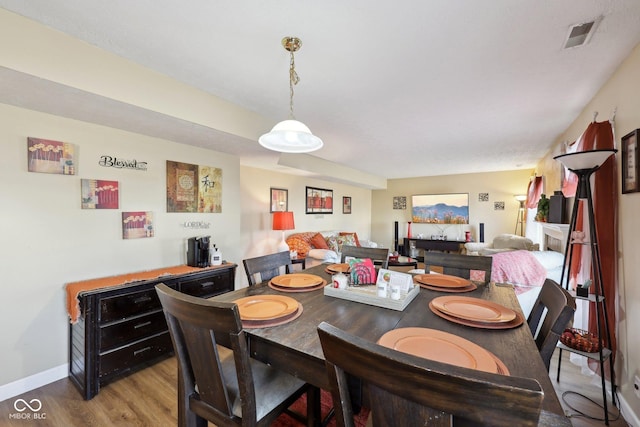 dining space featuring visible vents, baseboards, and wood finished floors