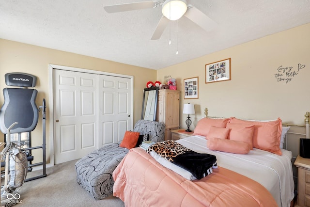 carpeted bedroom featuring a closet, a textured ceiling, and ceiling fan