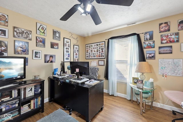 office area featuring visible vents, baseboards, a textured ceiling, and wood finished floors