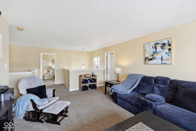 living area featuring carpet, baseboards, and a textured ceiling