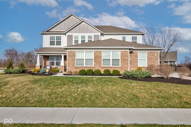 craftsman house featuring a front lawn, brick siding, board and batten siding, and roof with shingles