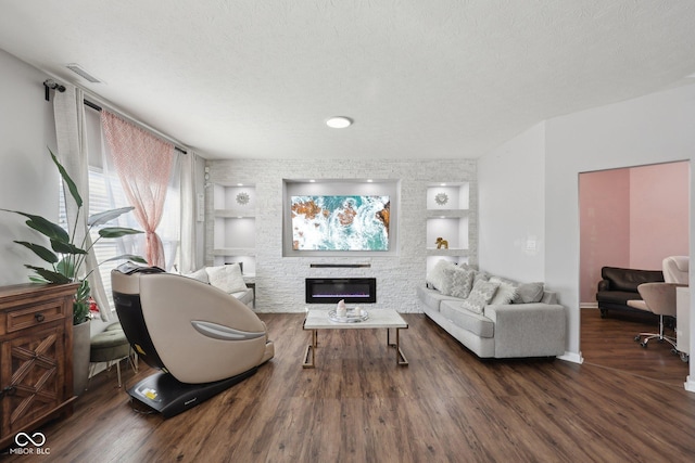 living room with a glass covered fireplace, built in features, a textured ceiling, and wood finished floors