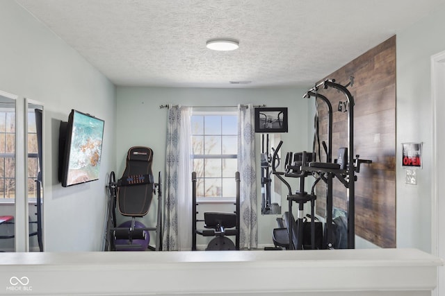 exercise area featuring visible vents and a textured ceiling