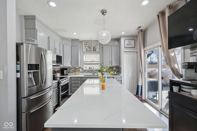 kitchen featuring a sink, a healthy amount of sunlight, gray cabinets, and stainless steel appliances