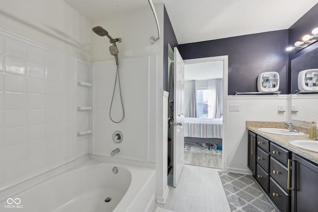 full bath with a sink, shower / bathtub combination, double vanity, and ensuite bathroom