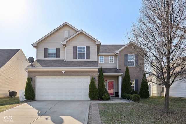 traditional-style house featuring concrete driveway, central air condition unit, brick siding, and a garage