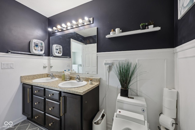 full bathroom with double vanity, toilet, and a sink