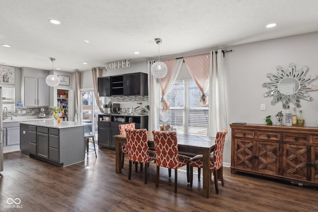 dining space with dark wood-style floors, recessed lighting, and a textured ceiling