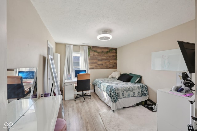 bedroom featuring a textured ceiling and light wood finished floors