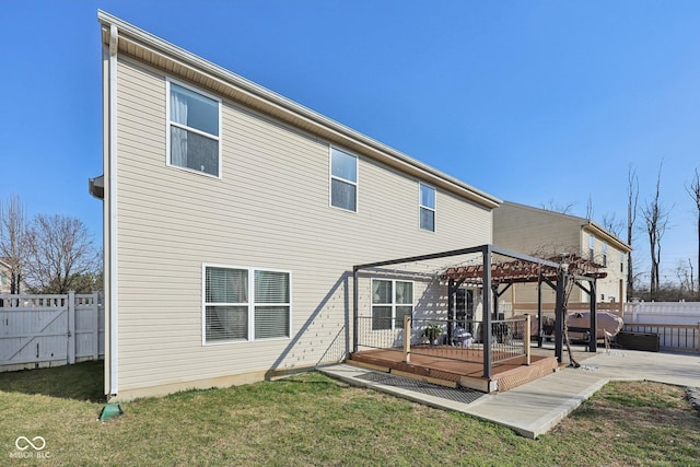 rear view of property featuring a yard, a wooden deck, a pergola, and a fenced backyard