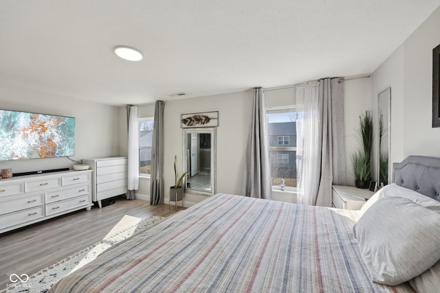 bedroom featuring visible vents and wood finished floors