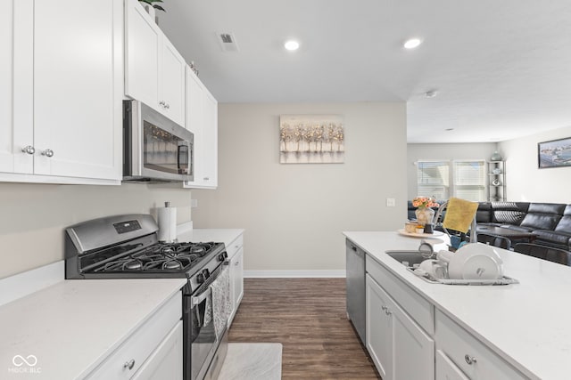 kitchen with visible vents, open floor plan, appliances with stainless steel finishes, white cabinets, and light countertops