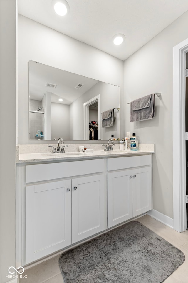 full bath featuring a sink, visible vents, double vanity, and tile patterned floors