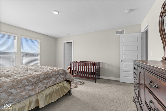 bedroom with visible vents, light colored carpet, and baseboards