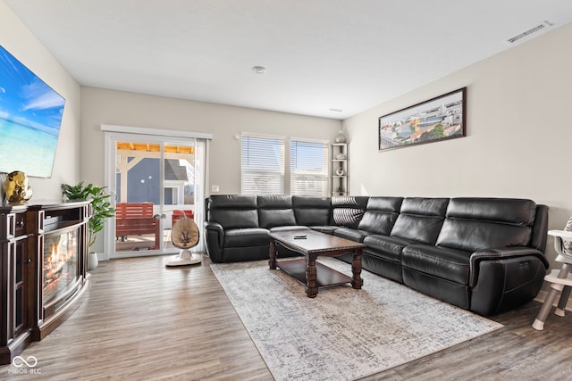 living area featuring visible vents and wood finished floors