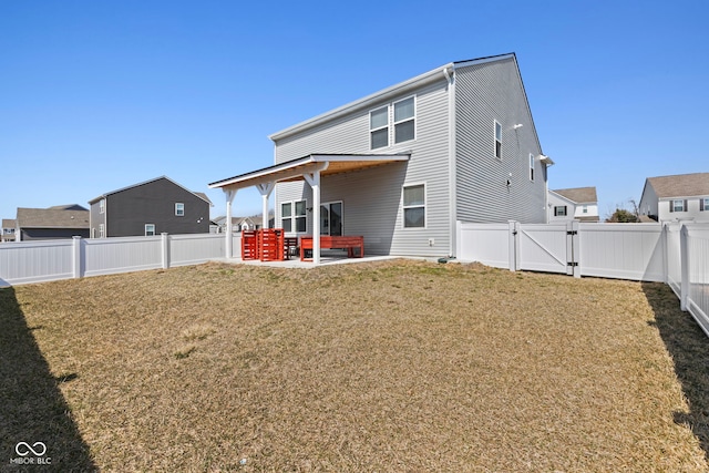 rear view of property with a patio area, a fenced backyard, a yard, and a gate