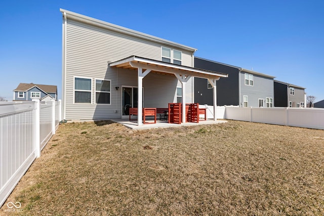 rear view of house with a patio area, a lawn, and a fenced backyard