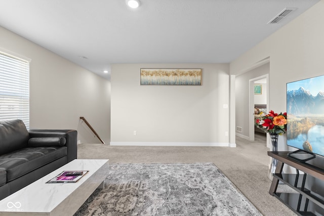 carpeted living area with baseboards and visible vents