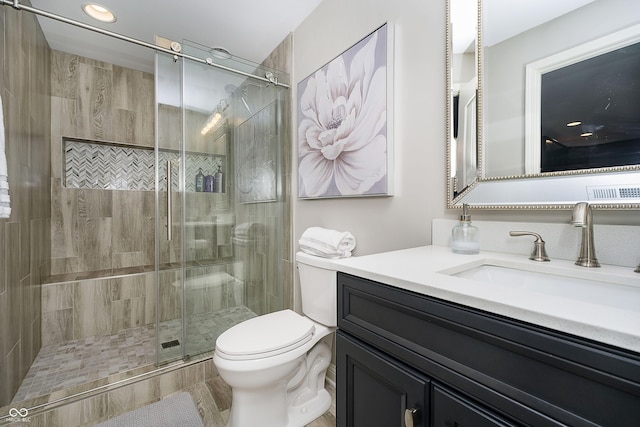 full bath with vanity, toilet, and a stall shower