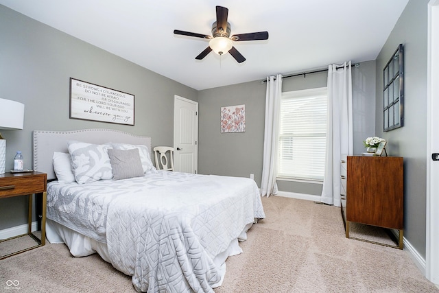 bedroom featuring a ceiling fan, light colored carpet, and baseboards