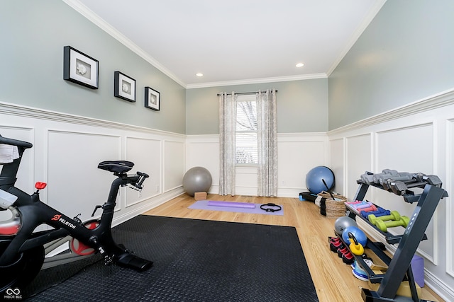 exercise room featuring recessed lighting, wainscoting, crown molding, and wood finished floors