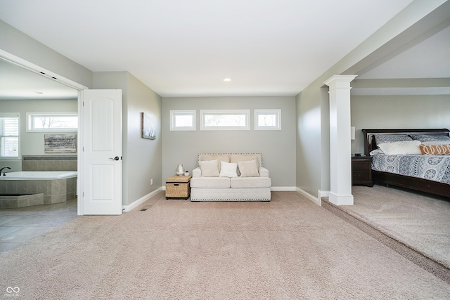 unfurnished bedroom with connected bathroom, baseboards, carpet, and ornate columns