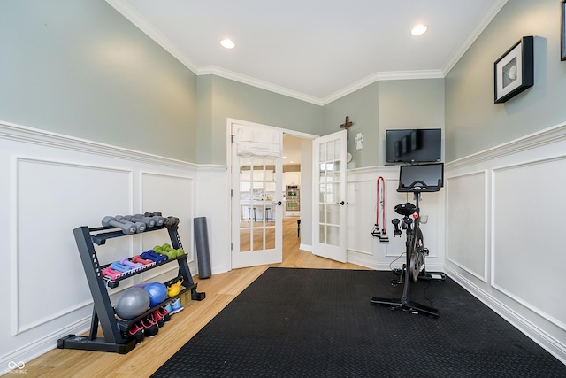 exercise area with a decorative wall, french doors, wood finished floors, and ornamental molding