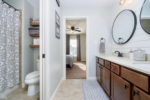 ensuite bathroom featuring ceiling fan, toilet, tile patterned flooring, and a sink