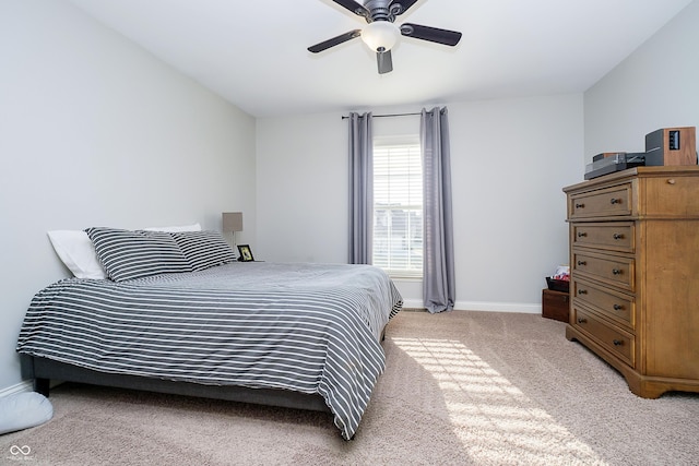 bedroom featuring baseboards, light colored carpet, and a ceiling fan