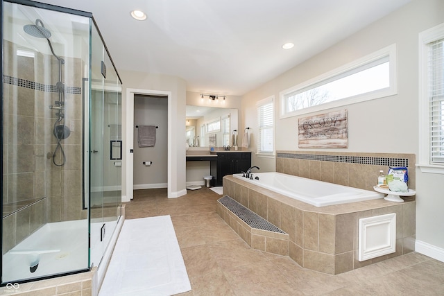 full bathroom with tile patterned flooring, baseboards, a stall shower, a bath, and vanity