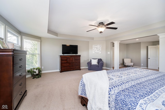 bedroom with decorative columns, baseboards, light carpet, and a ceiling fan