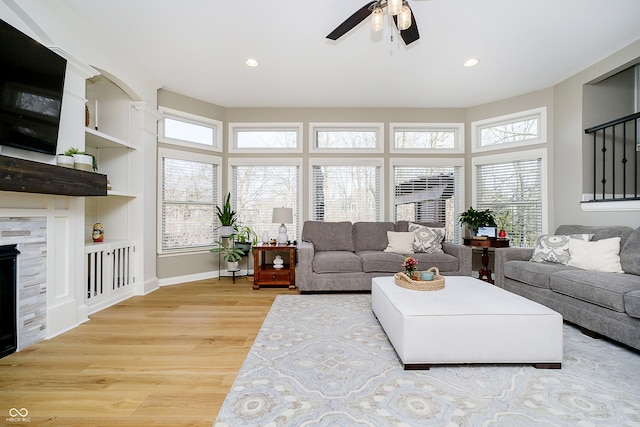 living area with built in shelves, a ceiling fan, recessed lighting, and light wood finished floors